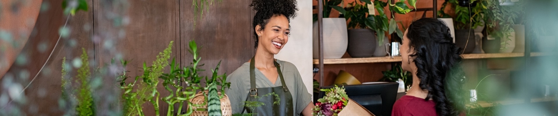Woman entrepreneur standing behind counter in plant store