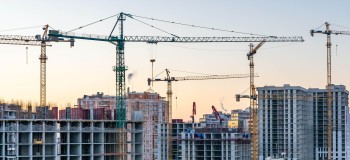 Construction site, cranes and multi storey unfinished buildings