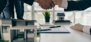 A home agent shakes hands with a customer