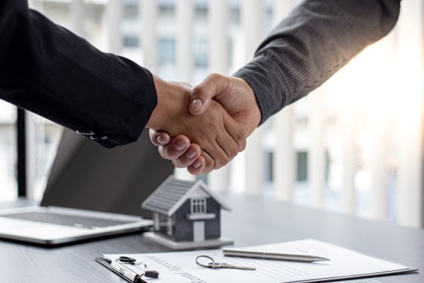 Real estate agents and customers shake hands
