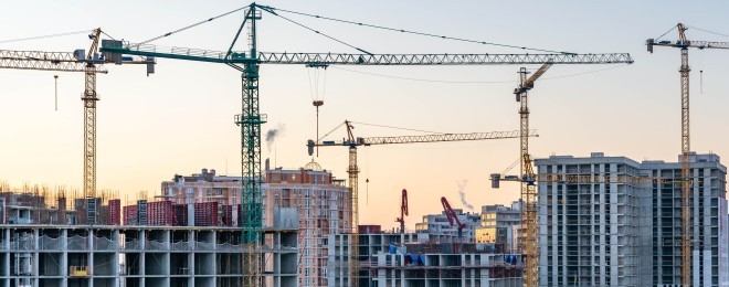 Construction site, cranes and multi storey unfinished buildings