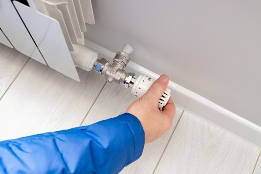 person adjusting radiator