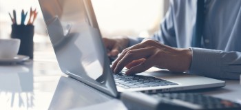 Business man or accountant working on laptop computer with business document graph diagram and calculator on office table scaled