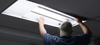 The man checking or changing Fluorescent light tube in the building scaled