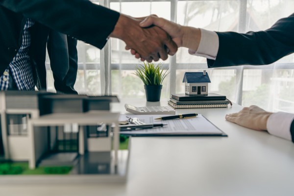 A home agent shakes hands with a customer