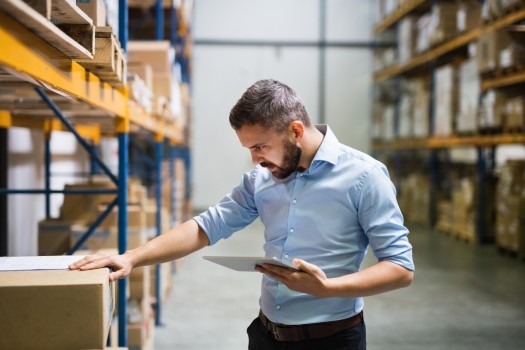 Man warehouse worker with a tablet 