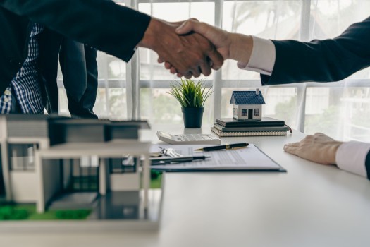 A home agent shakes hands with a customer